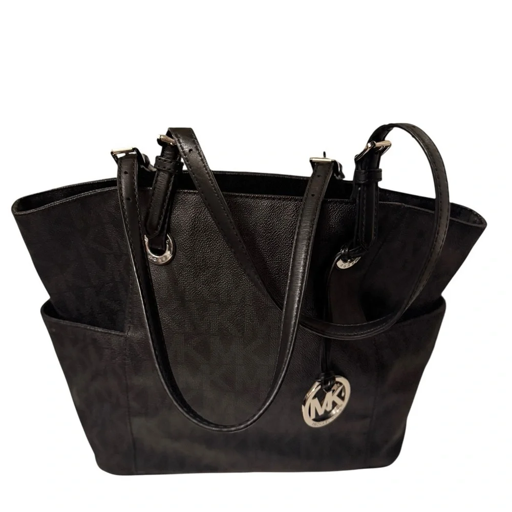 Michael Kors Elegant Black Handbag. Sides packets with a log in the front